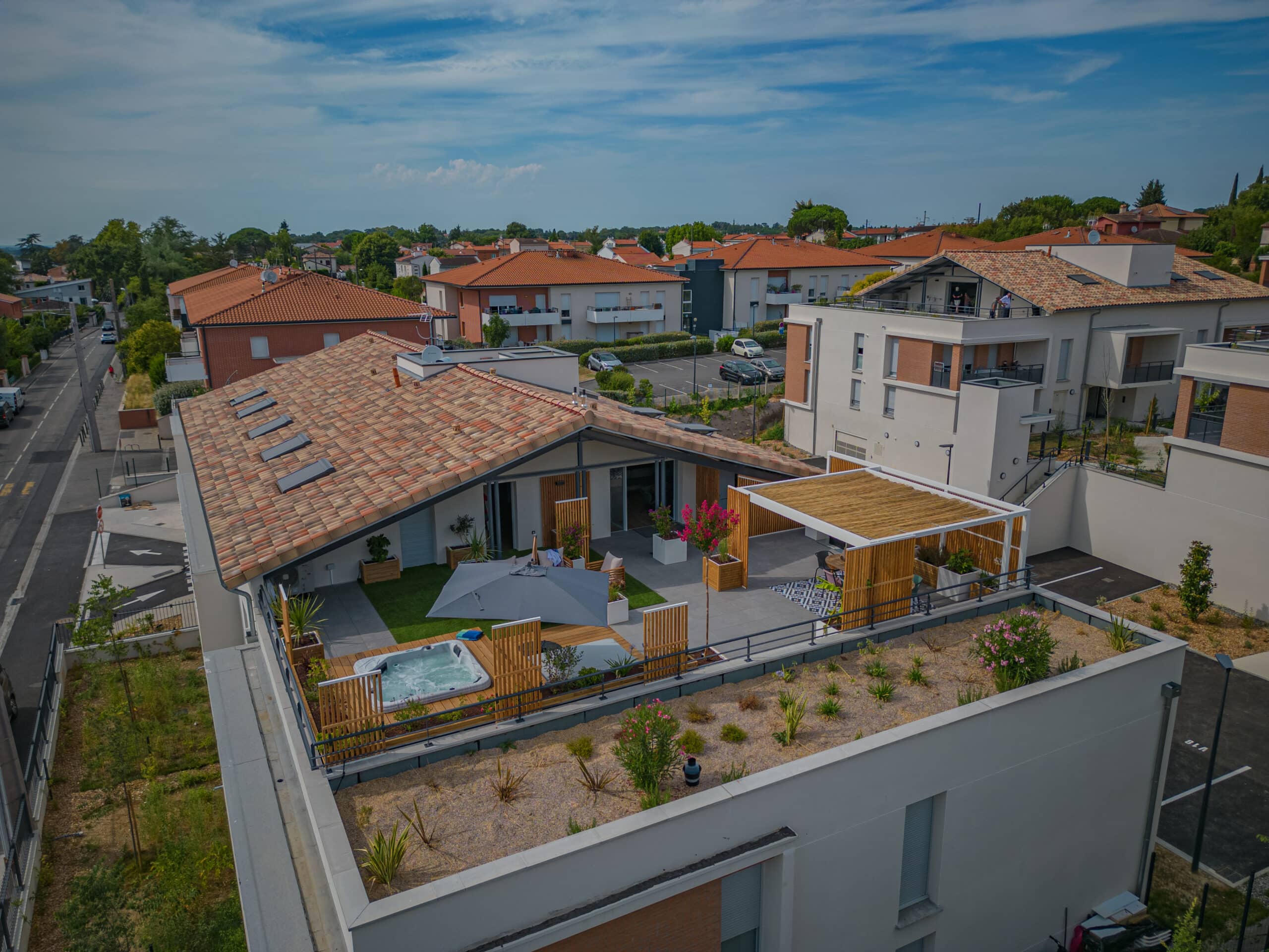 Toit-terrasse aménagé avec jacuzzi, pergola et espace détente surplombant un quartier résidentiel calme.