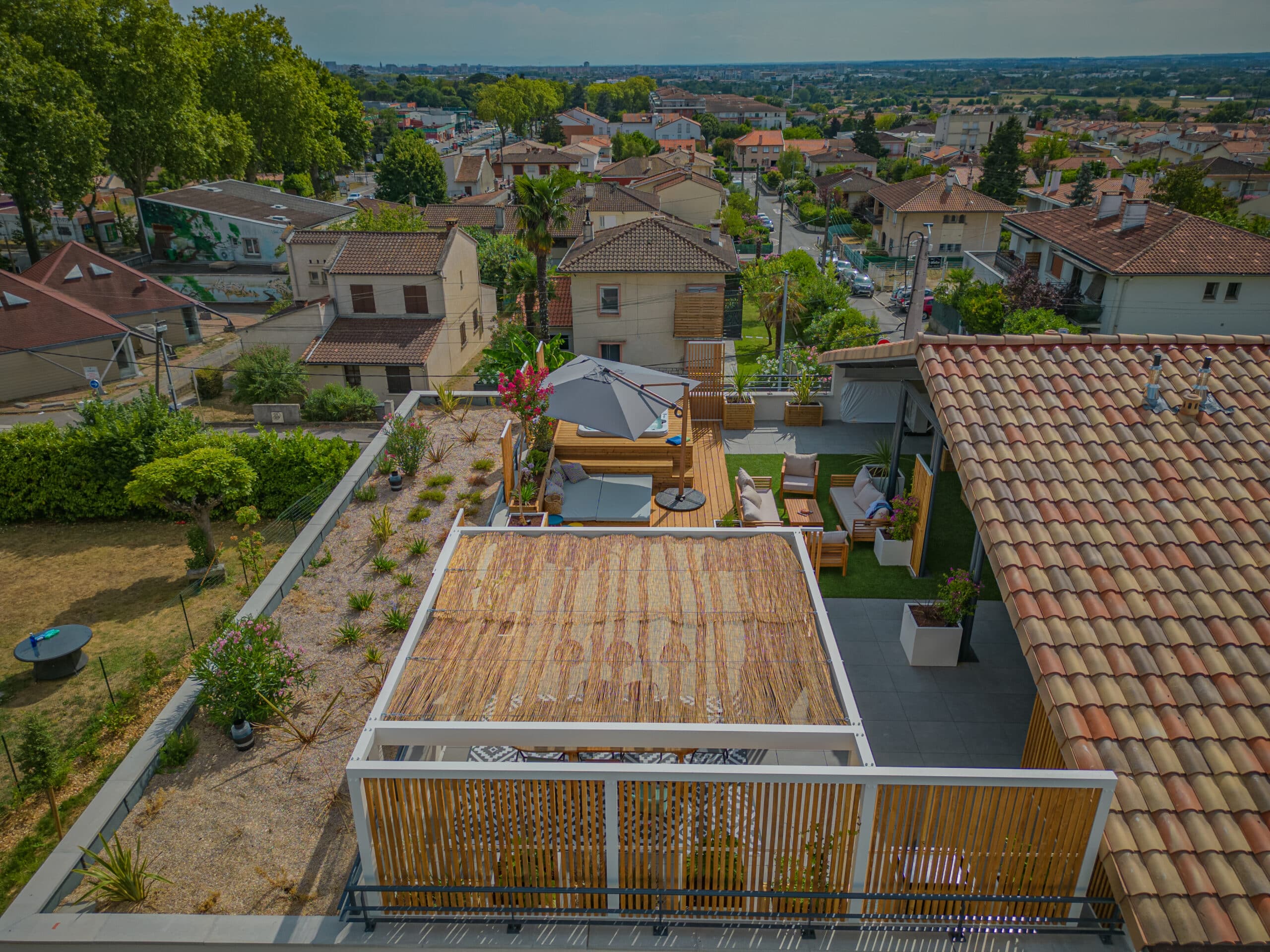 Toit-terrasse moderne avec pergola, jacuzzi et salon de jardin offrant une vue panoramique sur la ville.
